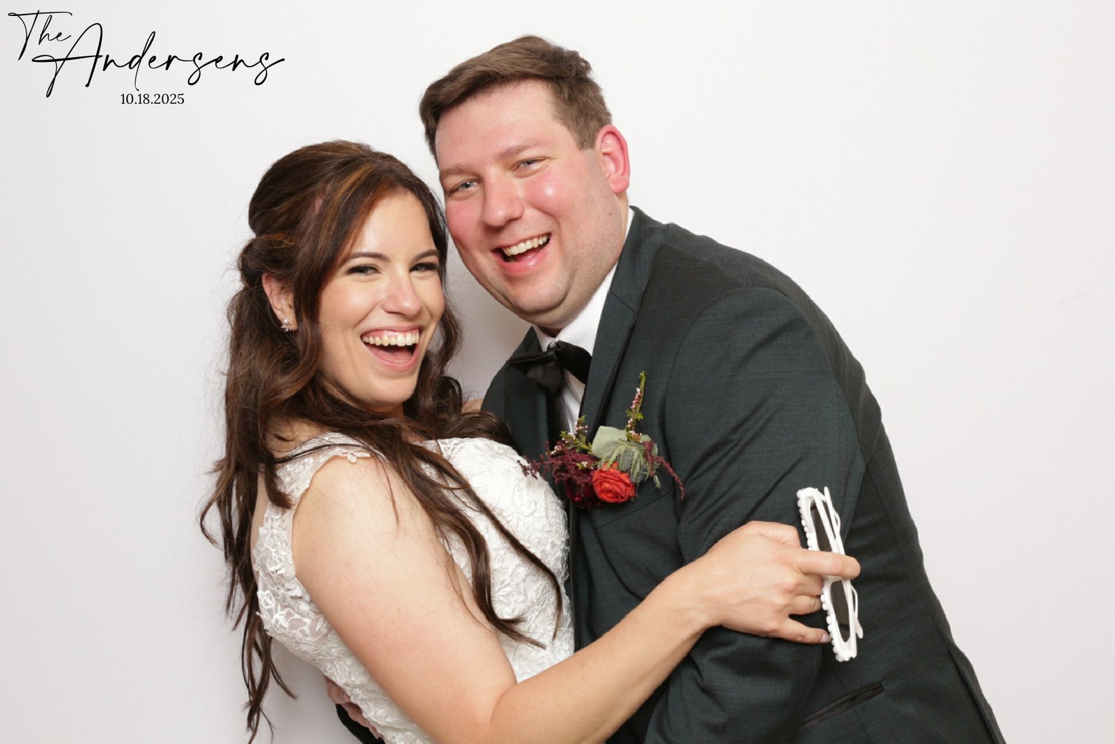 A bride and groom laughing together in the photo booth