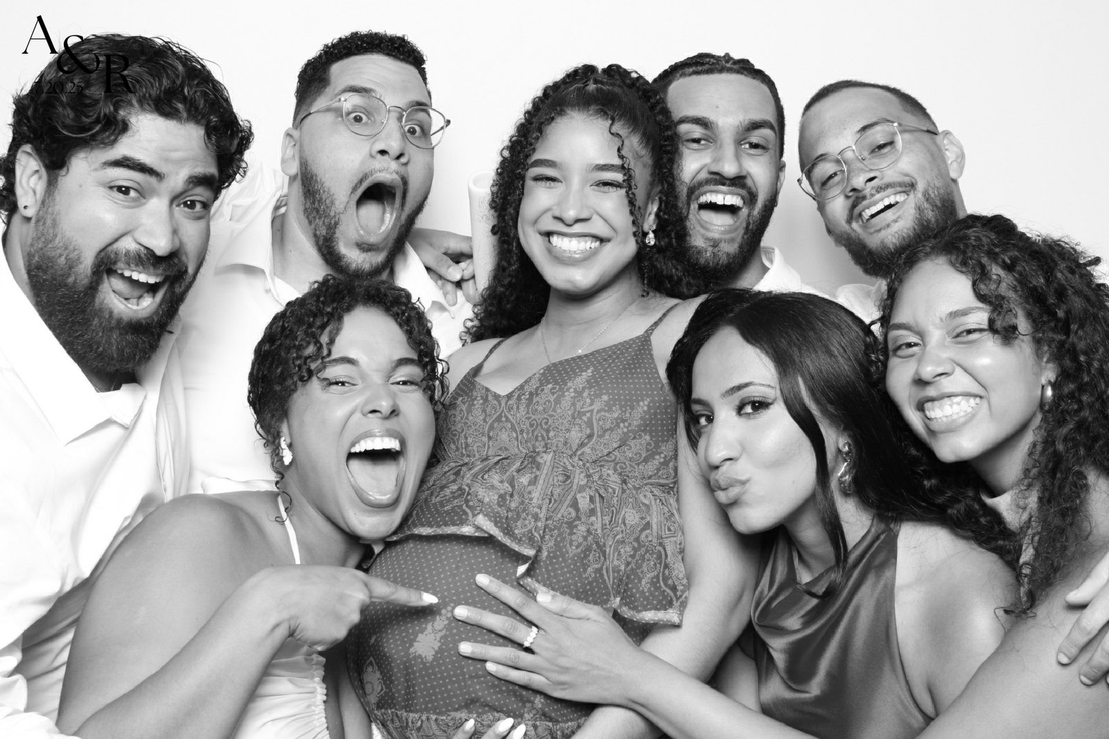A group of wedding guests laughing together in the photo booth