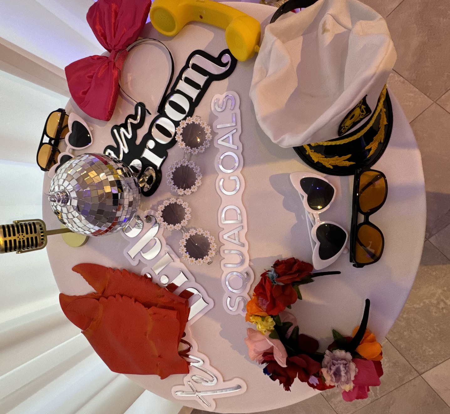 A round table of photo booth props laid out ready for guests